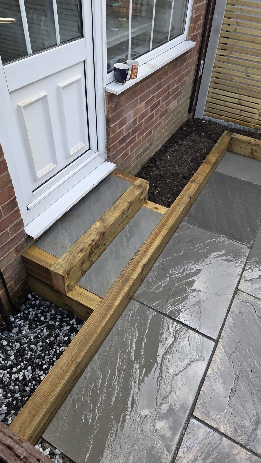 Kandla Grey Indian stone with fencing, sleeper planters and steps in Farsley
