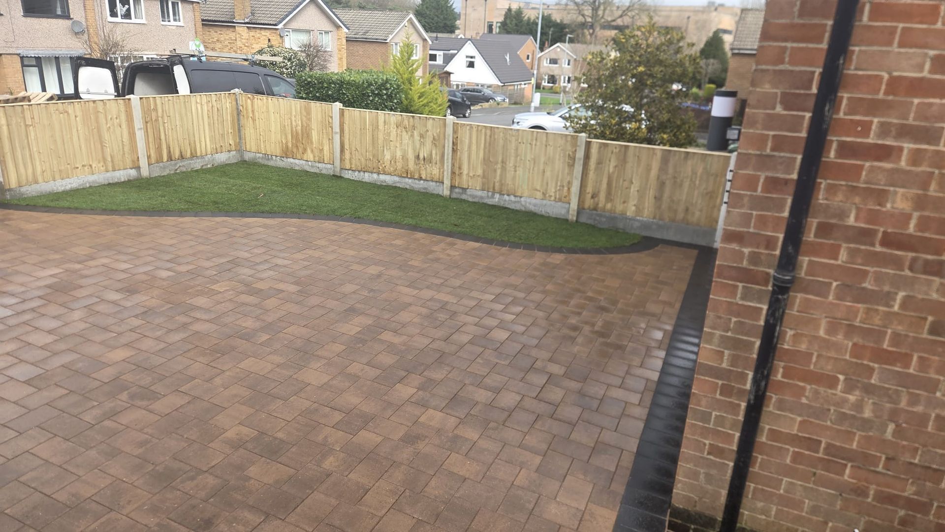 Completed block paved garden patio with new lawn and timber boundary fencing