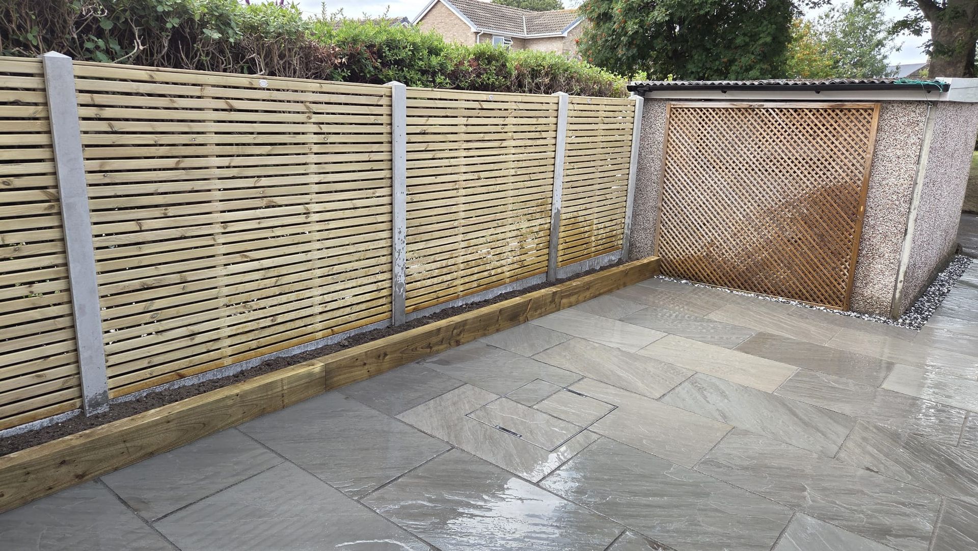 Kandla Grey Indian stone with fencing, sleeper planters and steps in Farsley