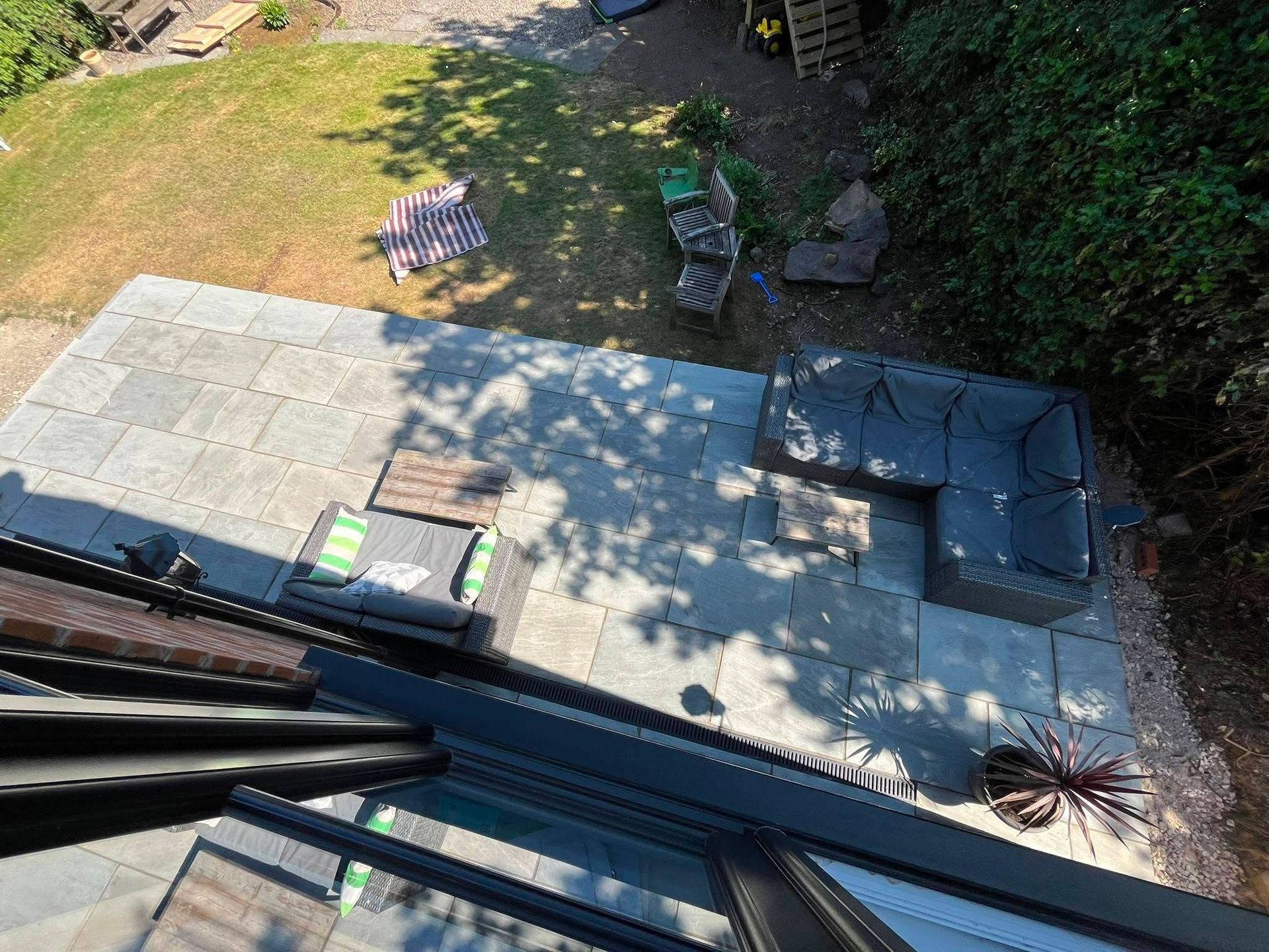 Raised grey patio beside a brick home in Horsforth
