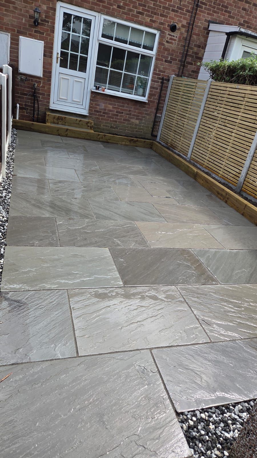 Kandla Grey Indian stone with fencing, sleeper planters and steps in Farsley