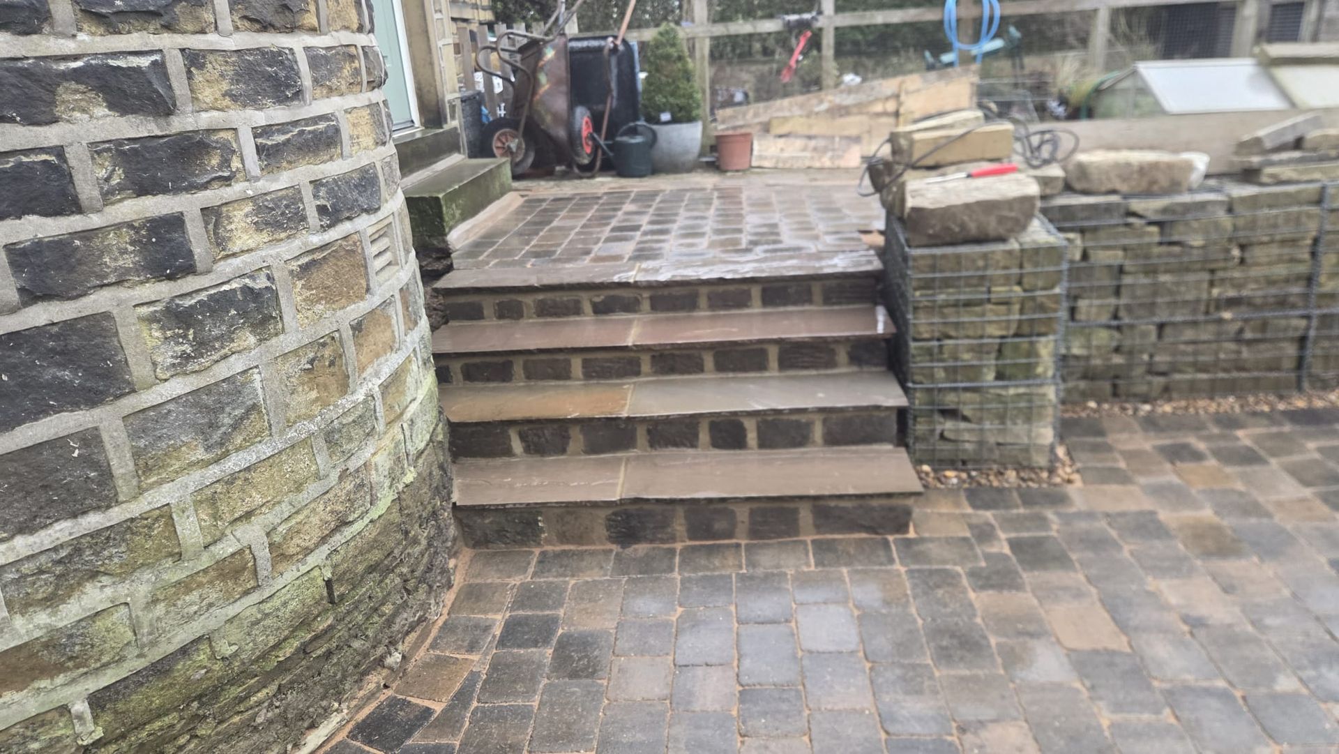 Stone paved garden terrace with wide coordinated masonry steps