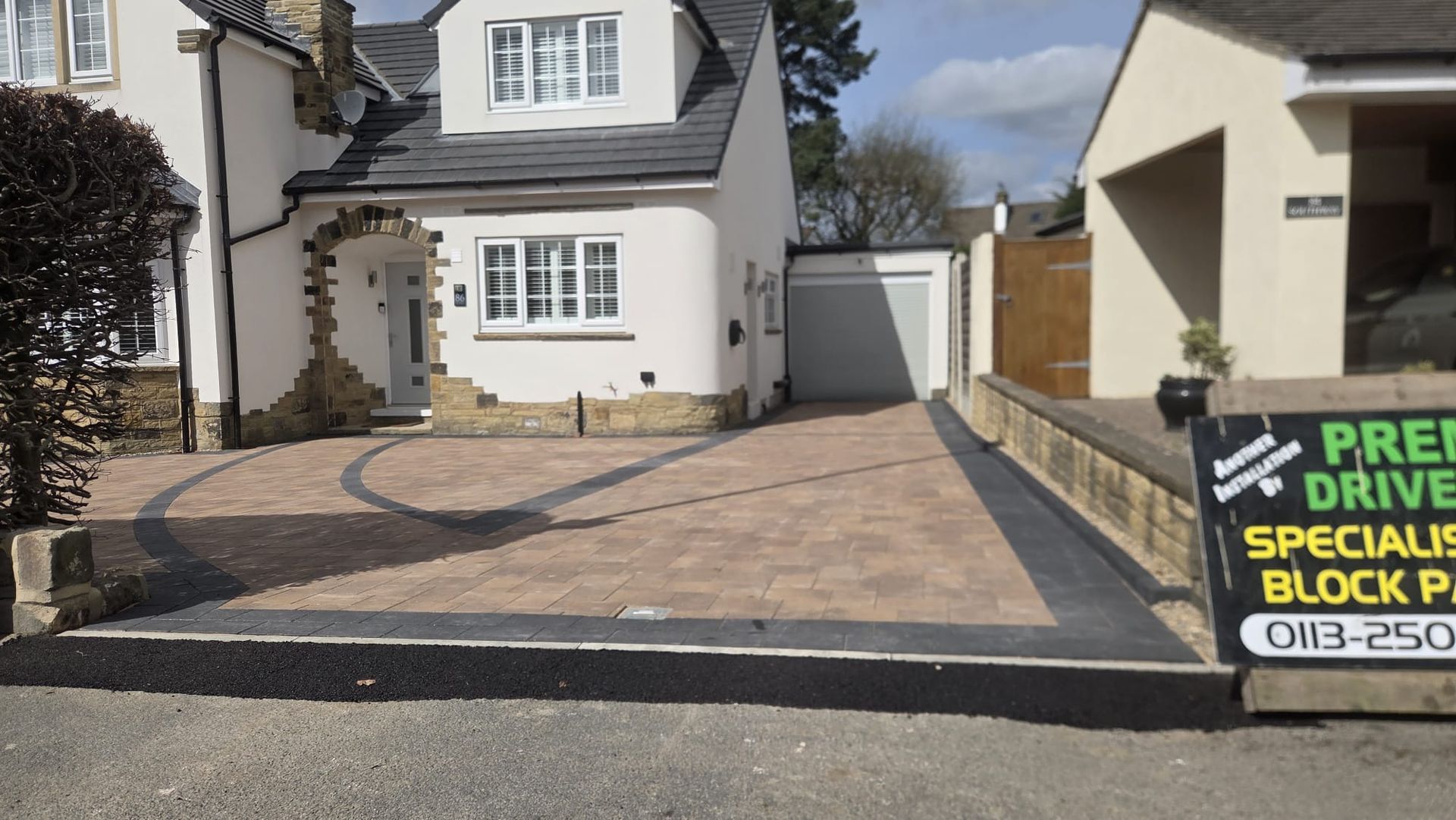 Curved block paving driveway with dark contrasting border and decorative layout