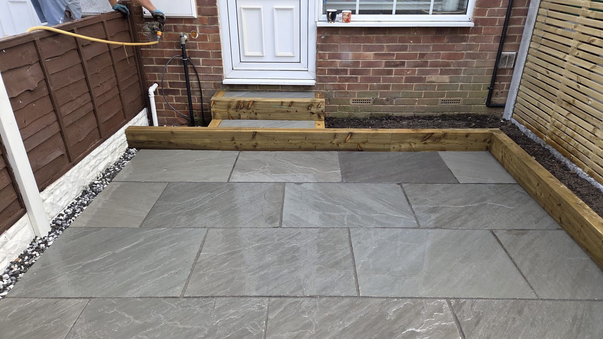 Kandla Grey Indian stone with fencing, sleeper planters and steps in Farsley
