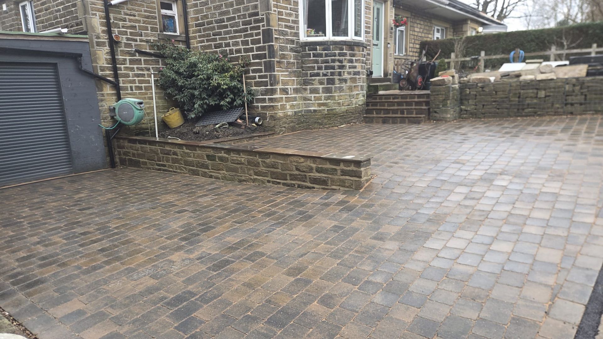Stone paved garden terrace with wide coordinated masonry steps