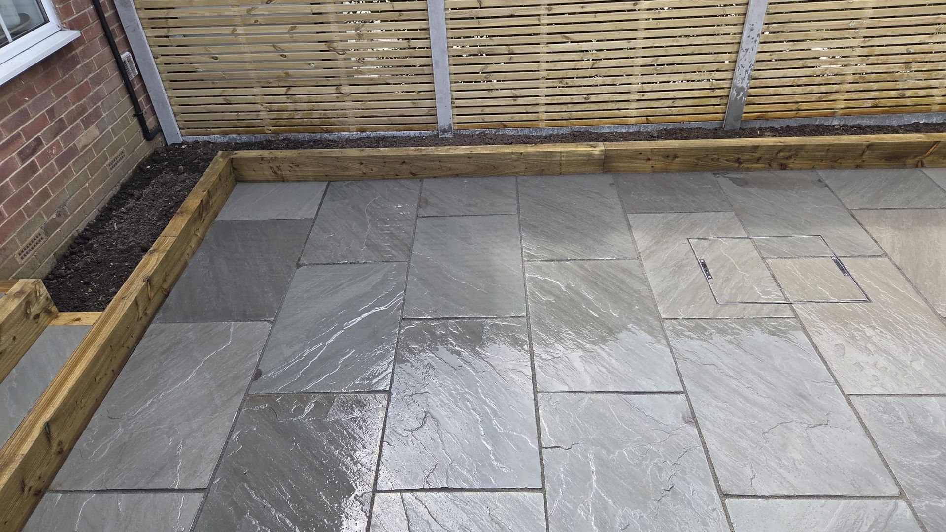 Kandla Grey Indian stone with fencing, sleeper planters and steps in Farsley