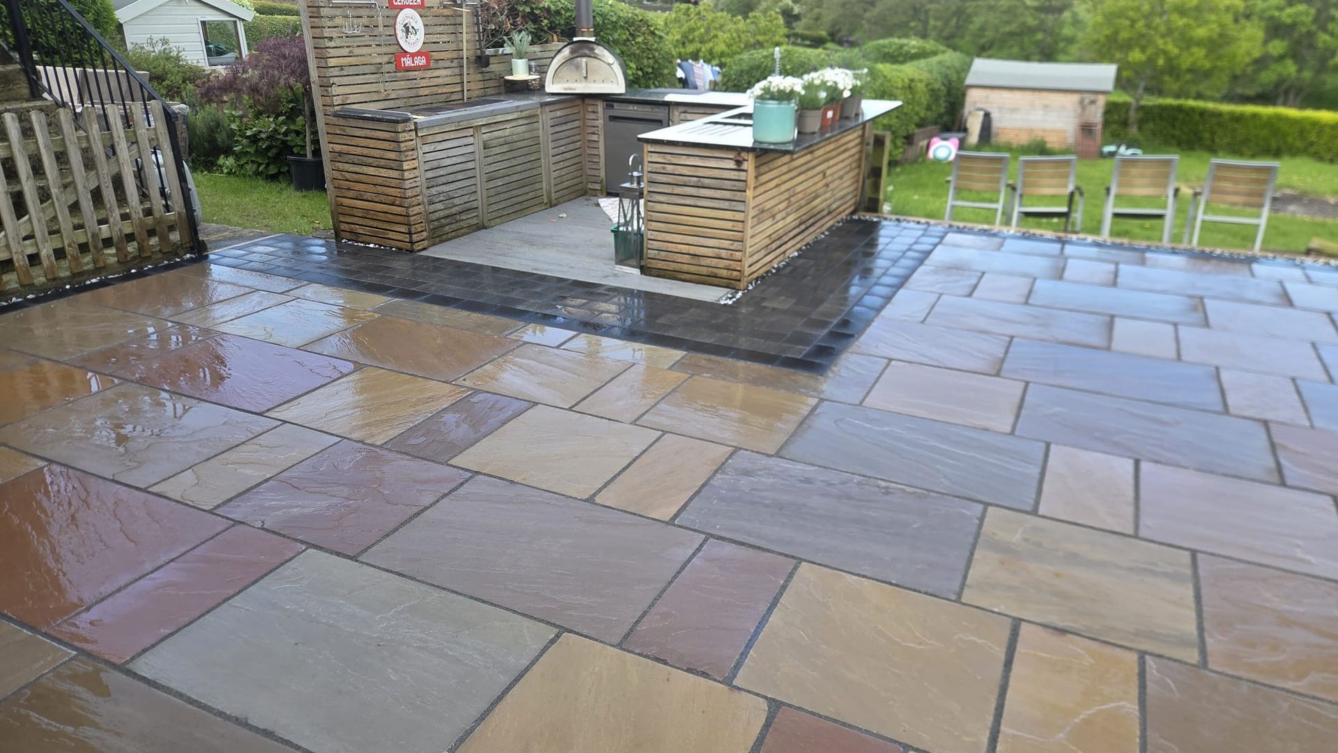 Indian sandstone patio with raised garden feature and coordinated paving