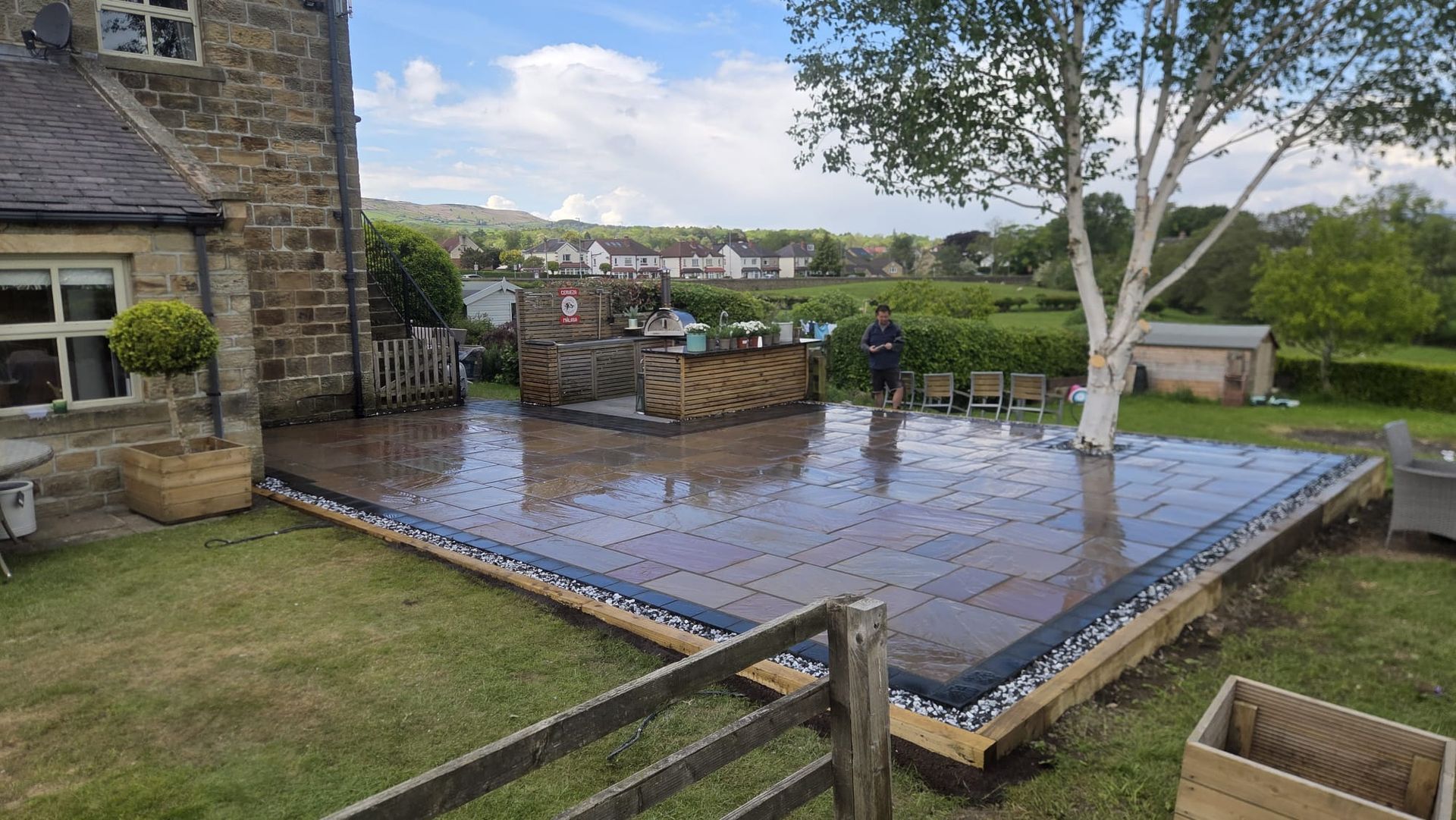 Indian sandstone patio with raised garden feature and coordinated paving